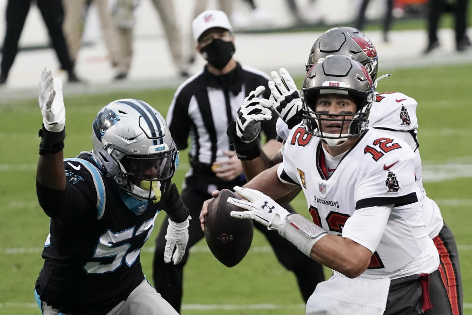 Tampa Bay Buccaneers quarterback Tom Brady (12) runs out of the pocket against Carolina Panthers defensive end Brian Burns (53) during the second half of an NFL football game, Sunday, Nov. 15, 2020, in Charlotte , N.C. (AP Photo/Gerry Broome)