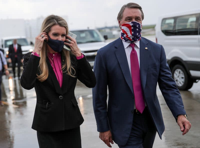 FILE PHOTO: Republican U.S. Senators from Georgia Loeffler and Perdue walk together at Hartsfield-Jackson Atlanta International Airport in Atlanta, Georgia