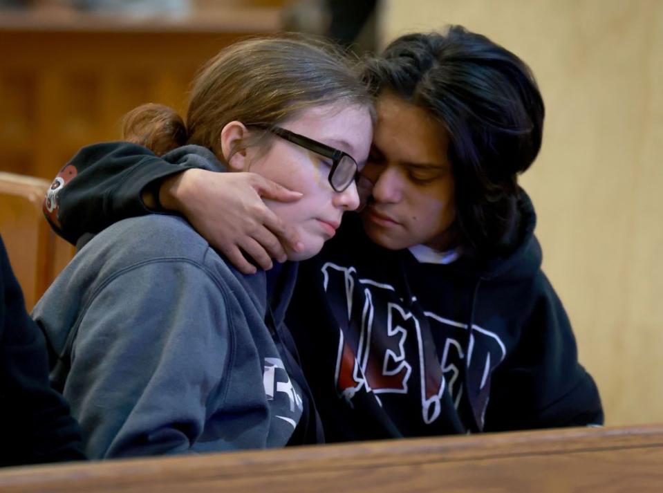 Mourners comfort one another at the Basilica of Saints Peter and Paul during Sunday's vigil.