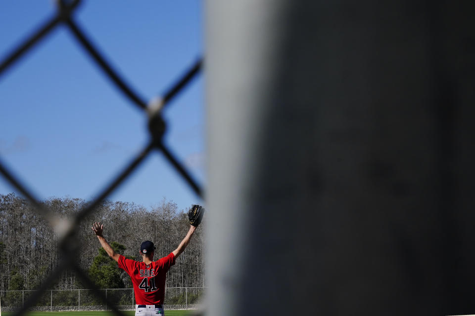 Boston Red Sox pitcher Chris Sale stretches before he runs onto the field to workout during spring training baseball practice on Monday, Feb. 22, 2021, in Fort Myers, Fla. (AP Photo/Brynn Anderson)