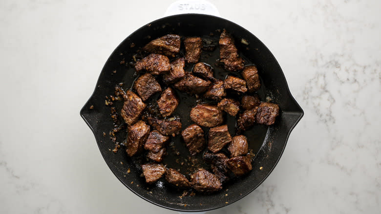 steak pieces in frying pan