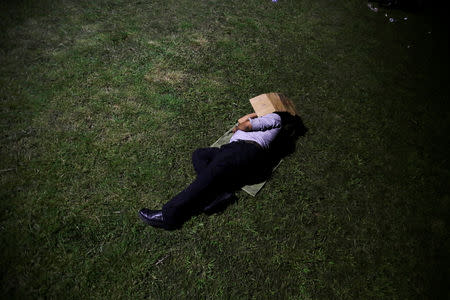 A Honduran man fleeing poverty and violence, rests before moving in a caravan toward the United States, outside the bus station in San Pedro Sula, Honduras October 12, 2018. Picture taken October 12, 2018. REUTERS/Jorge Cabrera