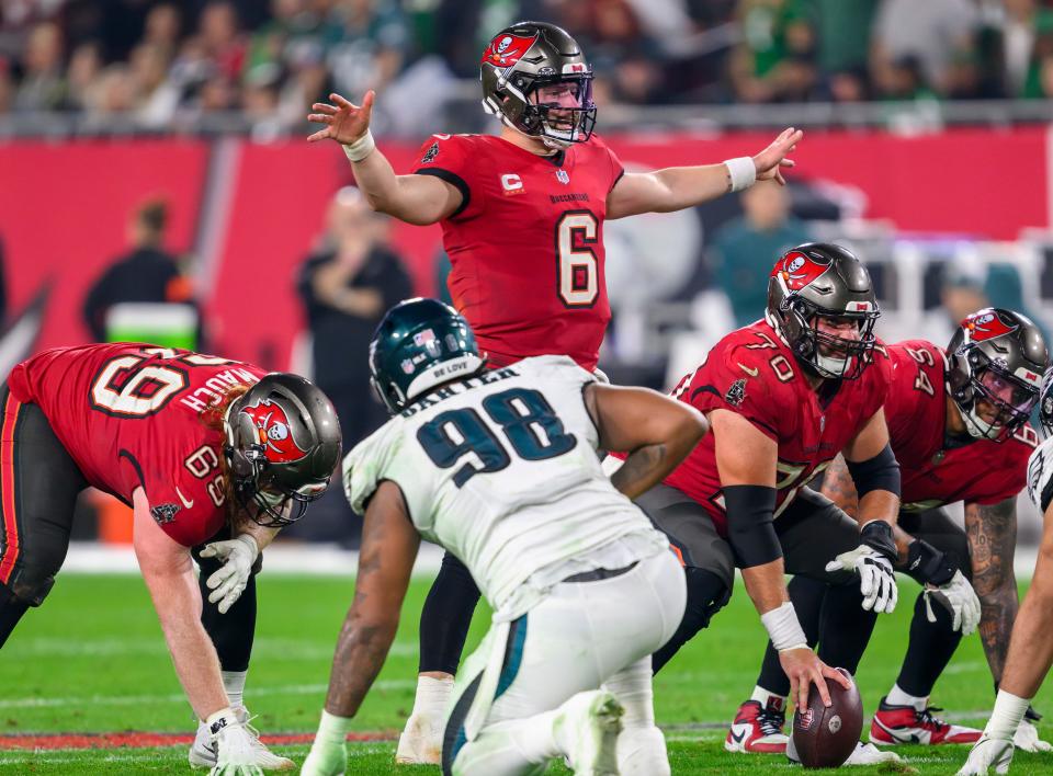 Tampa Bay Buccaneers quarterback Baker Mayfield (6) gestures as he prepares to take the snap of the ball from center Robert Hainsey (70) along with guard Cody Mauch (69) and guard Aaron Stinnie (64) during an NFL wild-card playoff football game against the Philadelphia Eagles, Monday, Jan. 15, 2024 in Tampa, Fla. (AP Photo/Doug Murray)