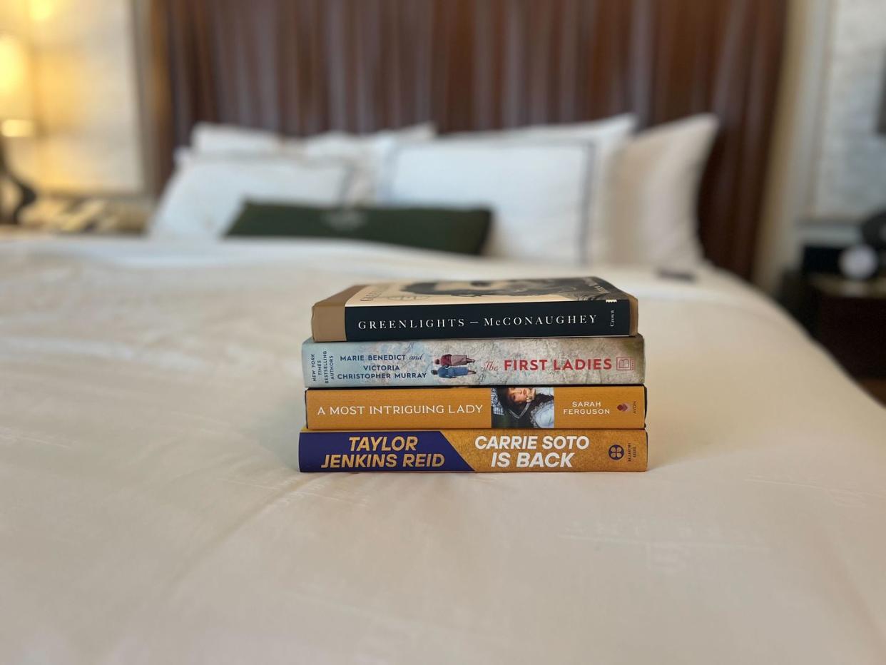 a stack of books on a bed
