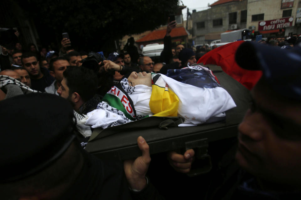 Palestinians carry the body of policeman Tariq Badwan during his funeral in the West Bank village of Azoun near Qalqilya, Friday, Feb. 7, 2020. Badwan was shot while standing at the entrance of a police station in Jenin, where Israeli forces clashed with Palestinians while demolishing the home of an alleged militant. He did not appear to have been involved in the clashes. (AP Photo/Majdi Mohammed)