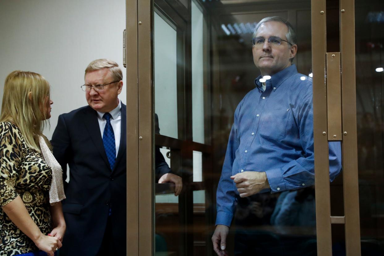 Paul Whelan, a former U.S. Marine who was arrested in Moscow at the end of last year, right, looks through a glass cage as his lawyers talk to each other in a courtroom in Moscow on Jan. 22, 2019.