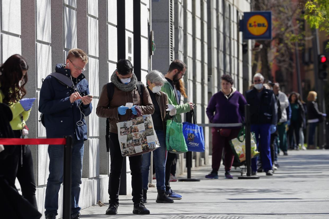 People line up to buy supplies from a supermarket during the coronavirus outbreak in Madrid, Spain, on Saturday, March 28, 2020.