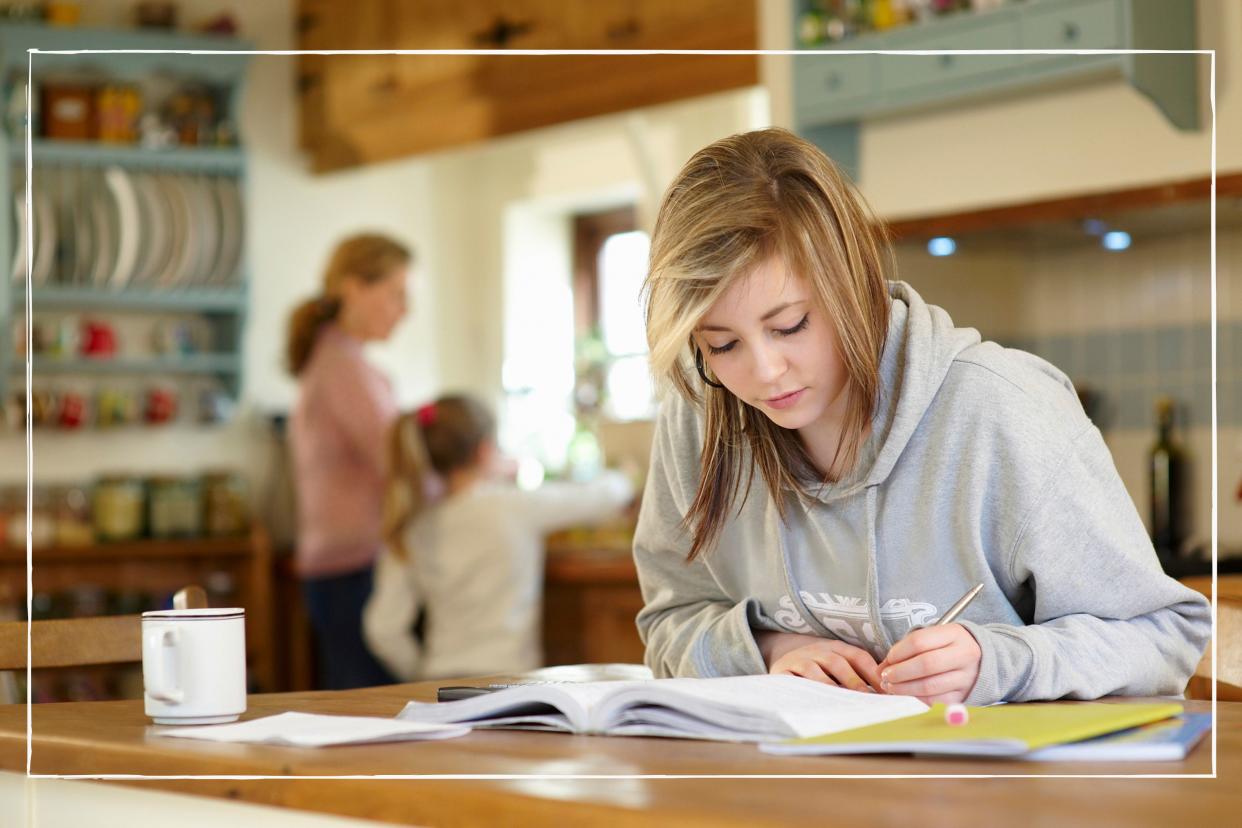  Teen doing homework or revising in the kitchen at home. 