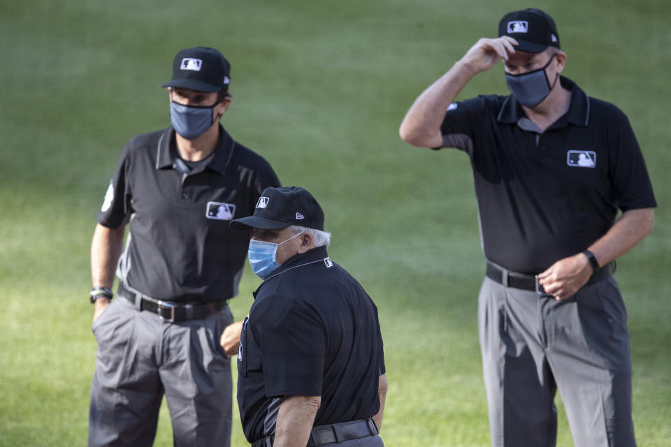 The umpires, wearing face masks, gather before an exhibition baseball game between the Washington Nationals and the Philadelphia Phillies at Nationals Park, Saturday, July 18, 2020, in Washington. (AP Photo/Alex Brandon)