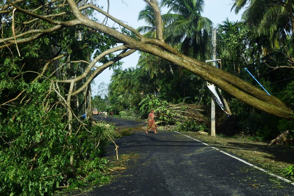 A woman removes debris from a road after the landfall of cyclone Amphan in Midnapore, West Bengal, on May 21, 2020. (Photo by DIBYANGSHU SARKAR/AFP via Getty Images)