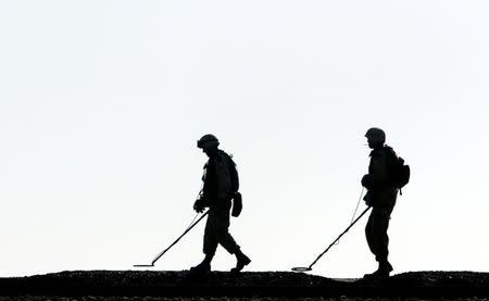 U.S. army mine sweepers search for mines on the outskirts of Ramadi December 10, 2003. REUTERS/Goran Tomasevic