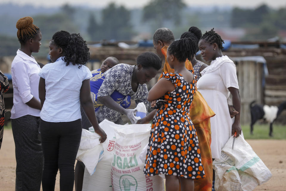 People receive a food distribution aimed to help those affected by the travel restrictions imposed in an attempt to limit the spread of Ebola, at a football pitch in Mubende, Uganda Tuesday, Nov. 1, 2022. Ugandan health officials say they have controlled the spread of a strain of Ebola that has no proven vaccine, but there are pockets of resistance to health measures among some in rural communities where illiteracy is high and restrictions on movement and business activity have left many bitter. (AP Photo/Hajarah Nalwadda)