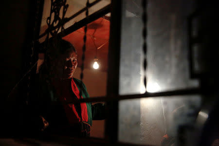 Refugee who fled fighting in neighbouring Myanmar looks from inside the house of a relative in the village of Baiyan near Nansan in the Yunnan province, China, March 11, 2017. REUTERS/Thomas Peter