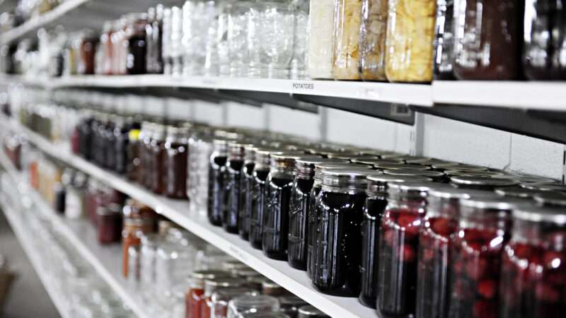 Jars of food sit on rows of shelves, as if preparing for hard times.