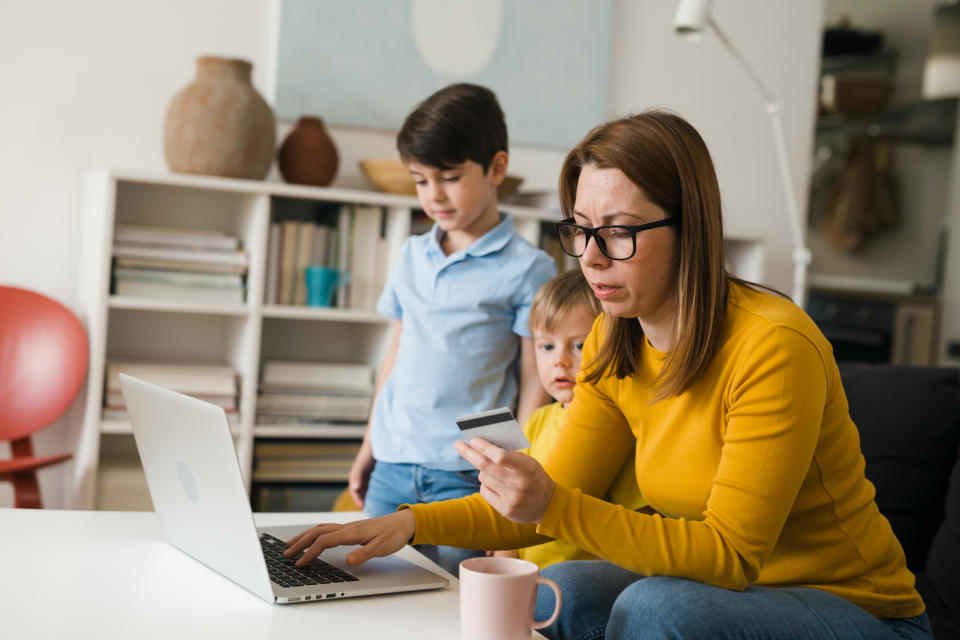 mother with her children shopping on line from their living room