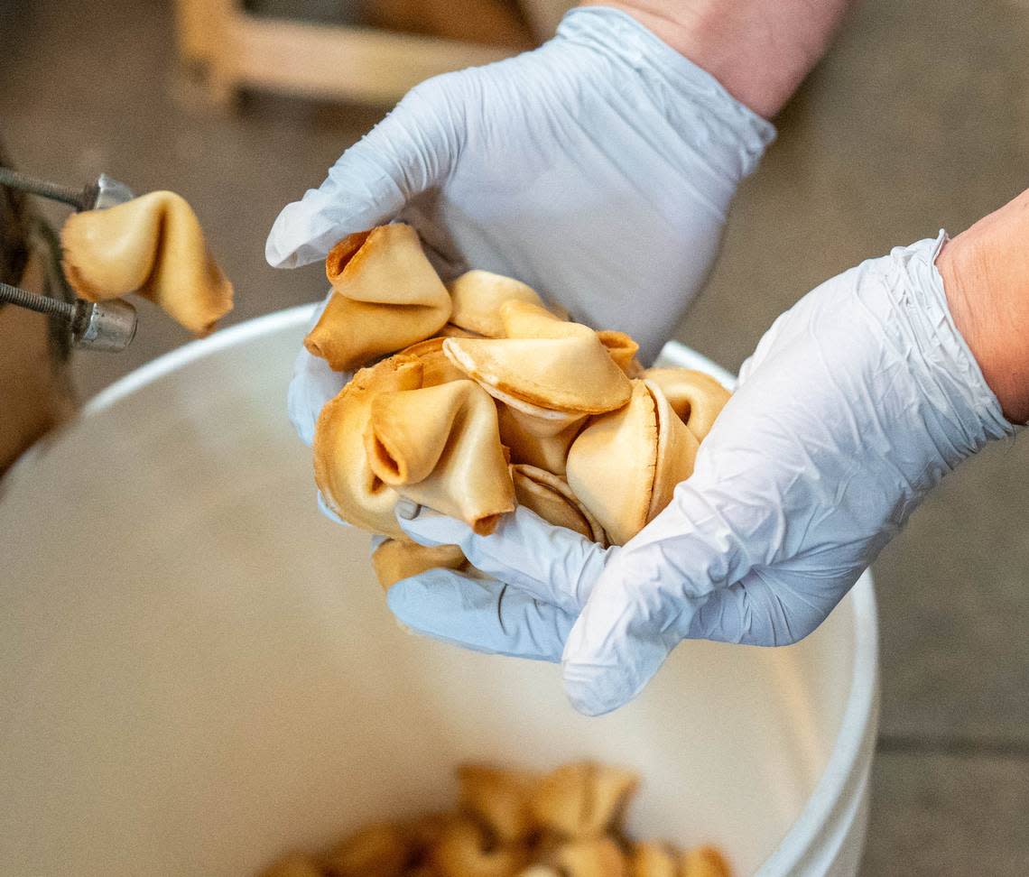 Newly made fortune cookies are scooped out of a bucket in New World Co. in April. Cameron Clark/cclark@sacbee.com
