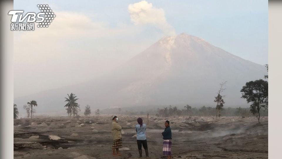 居民從遠方觀看噴發的塞梅魯火山，天空因為火山灰等而變得霧矇矇。（圖／達志影像美聯）