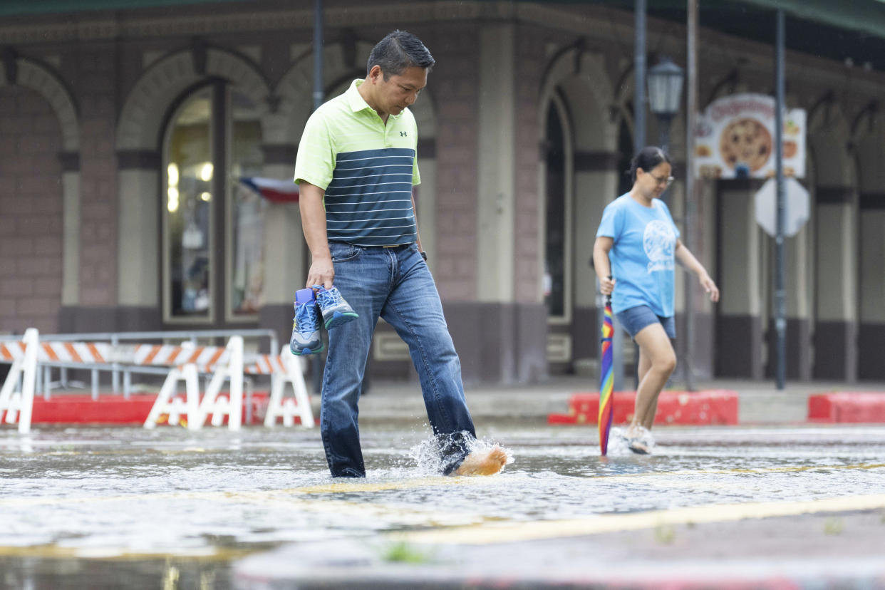 Roy Quiroz and his wife, Minda, walk in the flooded streets of Galveston, Texas.