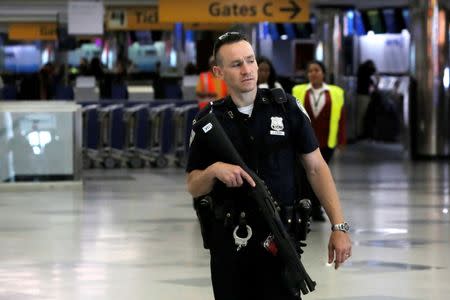 A Port Authority Police Officer monitors the departures area at LaGuardia Airport in the lead up to the holiday weekend in the Queens borough of New York, U.S., June 29, 2016. REUTERS/Andrew Kelly