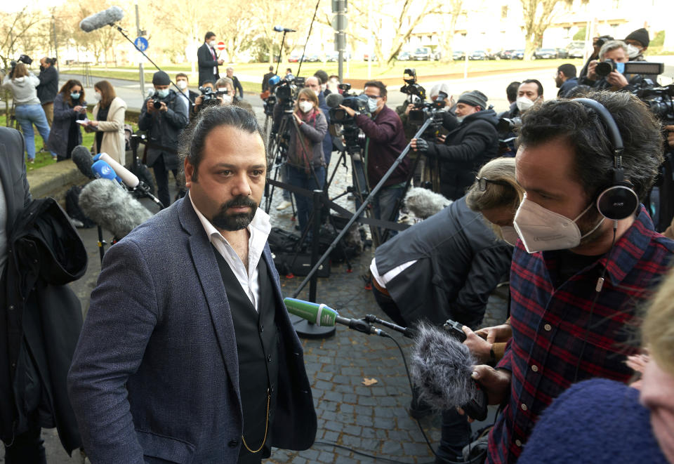 FILE - Wassim Mukda, front left, talks to journalists after the pronouncement of the verdict in front of the building of the Higher Regional Court in Koblenz, Feb. 24, 2021. A court in the German city of Koblenz is scheduled to deliver its ruling Thursday in the trial of Anwar Raslan, a former Syrian secret police officer who is accused of crimes against humanity for overseeing the abuse of detainees at a jail near Damascus a decade ago.Victims of torture in Syria and human rights activists say they hope the upcoming verdict in a landmark trial will be a first step toward justice for countless Syrians who suffered abuse at the hands of President Bashar Assad's government in the country's long-running conflict. (Thomas Frey/dpa via AP,file)