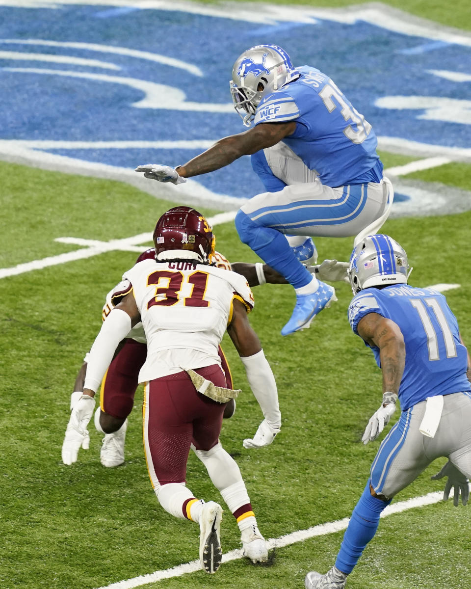 Detroit Lions running back D'Andre Swift (32) leaps over Washington Football Team safety Deshazor Everett (22) during the first half of an NFL football game Sunday, Nov. 15, 2020, in Detroit. (AP Photo/Carlos Osorio)