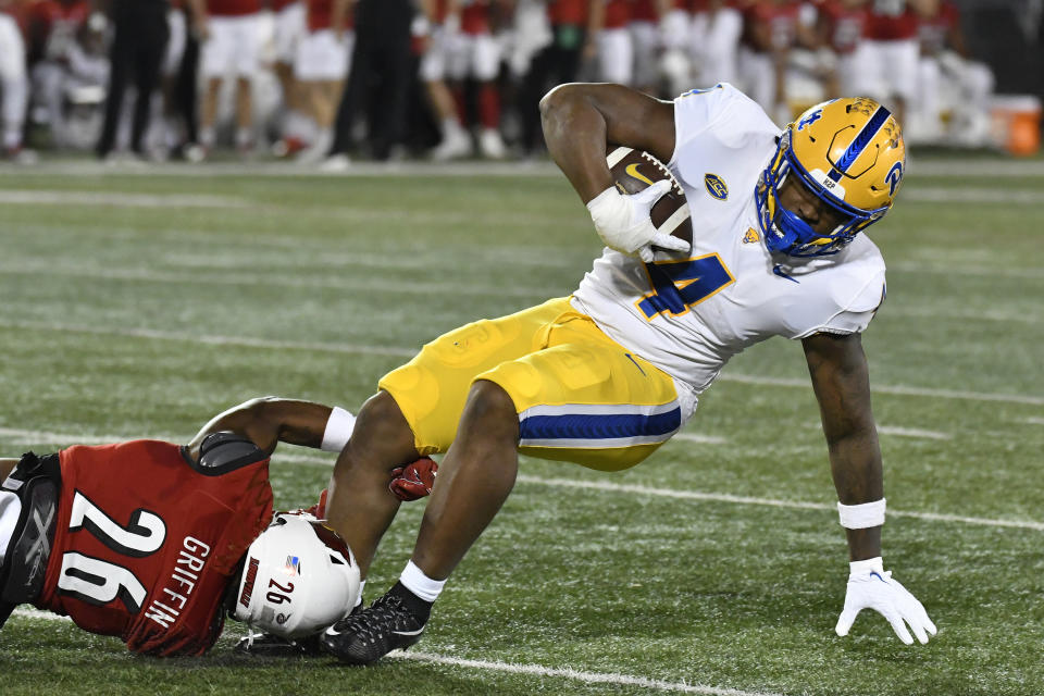 Pittsburgh running back Daniel Carter (4) is brought down by Louisville safety M.J. Griffin (26) during the first half of an NCAA college football game in Louisville, Ky., Saturday, Oct. 22, 2022. (AP Photo/Timothy D. Easley)