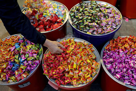 A man buys candies as he prepares for Chinese Lunar New Year of the Dog, at a market in Taipei, Taiwan February 12, 2018. REUTERS/Tyrone Siu