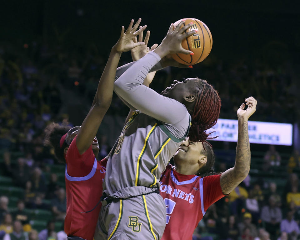 Baylor guard Aijha Blackwell (33) shoots between Delaware State forward Tyshonne Tollie (22), left, and Delaware State guard Naomi Zulueta (2) during the first half of an NCAA college basketball game Thursday, Dec.14, 2023, in Waco, Texas.(Jerry Larson/Waco Tribune-Herald via AP)