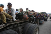 Honduran migrants bound to the U.S border sit on trailers in Zacapa, Guatemala, Wednesday, Oct. 17, 2018. The group of some 2,000 Honduran migrants hit the road in Guatemala again Wednesday, hoping to reach the United States despite President Donald Trump's threat to cut off aid to Central American countries that don't stop them. (AP Photo/Moises Castillo)