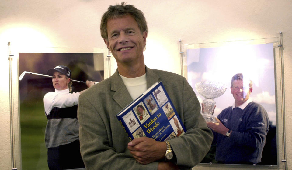 FILE - In this Aug. 21, 2003 file photo Alastair Johnston, vice chairman of IMG, poses outside his office with one of his books in Cleveland. Johnston has the largest collection of golf books in the world, and he' s gifting it to the R&A. (AP Photo/Jamie-Andrea Yanak, file)