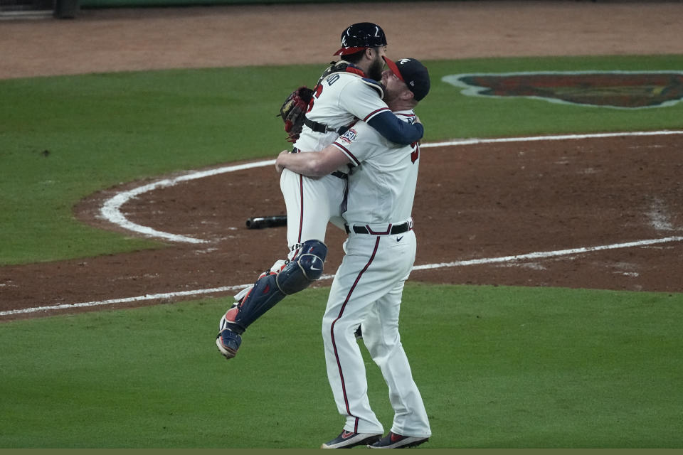 Atlanta Braves catcher Travis d'Arnaud hugs pitcher Will Smith after winning Game 6 of baseball's National League Championship Series against the Los Angeles Dodgers Saturday, Oct. 23, 2021, in Atlanta. The Braves defeated the Dodgers 4-2 to win the series. (AP Photo/John Bazemore)