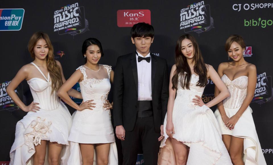 South Korean pop group Sistar poses with singer Junggigo on the red carpet as they attend the 2014 Mnet Asian Music Awards (MAMA) in Hong Kong
