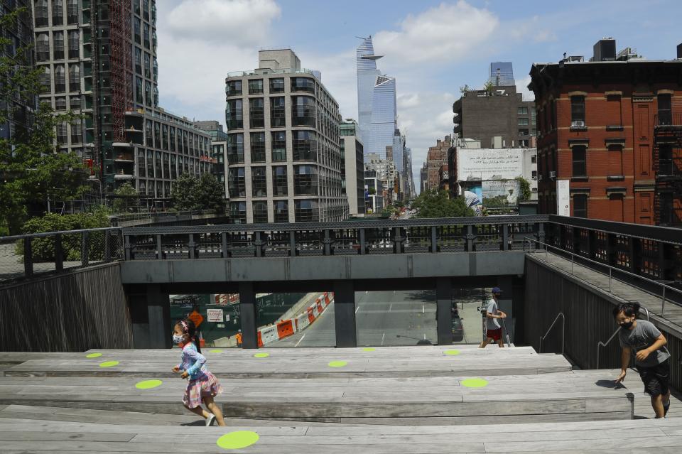 Children wearing protective masks during the coronavirus pandemic play at the High Line Park, Thursday, July 16, 2020, in New York. The High Line opened today after having been closed the last few months during the pandemic. (AP Photo/Frank Franklin II)