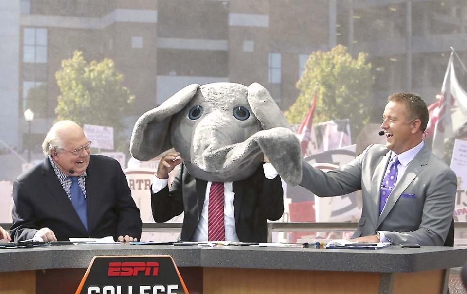 ESPN's Lee Corso wears Big Al's mascot head after picking Alabama to win over Texas A&M as Vern Lundquist, left, and Kirk Herbstreit laugh on the set of ESPN's College GameDay outside Bryant-Denny Stadium in Tuscaloosa, Alabama, on Oct. 22, 2016.