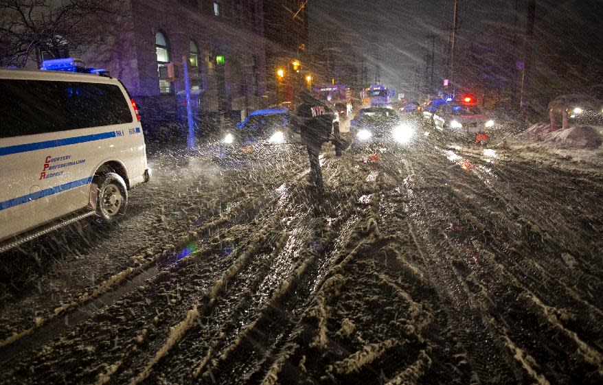 FILE - In this Wednesday, Nov. 7, 2012 file photo, a member of the New York Police Department walks through snow as it accumulates in the Rockaway Beach neighborhood of the borough of Queens, New York in the wake of Superstorm Sandy. Hundreds of New York City police officers and firefighters who have spent the past few weeks helping a storm-battered city get back on its feet are also dealing with personal losses related to the floods. The NYPD and FDNY say an estimated 1,700 members of their departments had homes, vehicles or other property severely damaged or lost when Sandy came ashore. (AP Photo/Craig Ruttle)