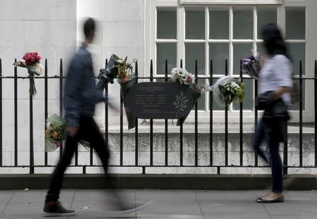 Passers-by look at a memorial plaque attached to railings in Tavistock Square, in memory of those who lost their lives on a number 30 double-decker bus during the 7/7 attack in 2005, in London, Britain, July 6, 2015. REUTERS/Peter Nicholls