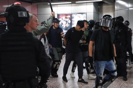 Riot police detain a man inside Prince Edward Mass Transit Railway (MTR) station after anti-extradition bill protest in Hong Kong