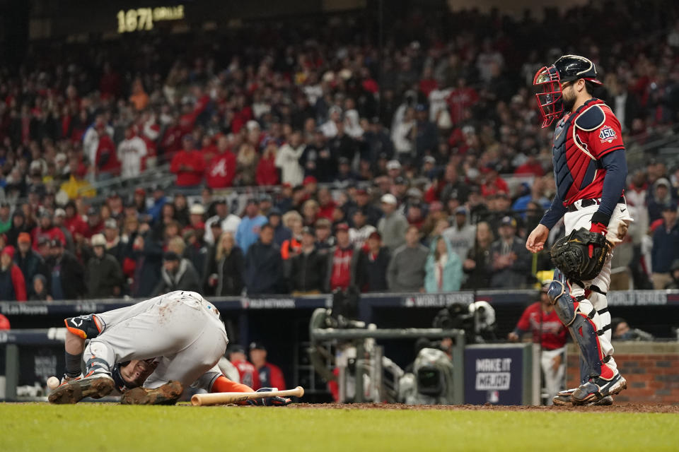 Atlanta Braves catcher Travis d'Arnaud watches as Houston Astros' Alex Bregman reacts after getting hit by a pitch during the sixth inning in Game 3 of baseball's World Series between the Houston Astros and the Atlanta Braves Friday, Oct. 29, 2021, in Atlanta. (AP Photo/David J. Phillip)