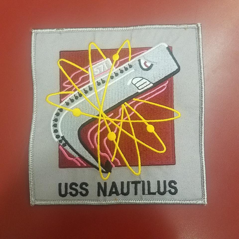 A jacket patch designed by Disney, representing the emblematic dolphin symbol of the USS Nautilus.