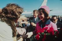<p>President John F. Kennedy and First Lady Jackie Kennedy shake hands with onlookers in the crowd after arriving at Dallas Love Field Airport. </p>