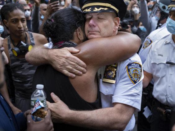 Chief of Department of the New York City Police, Terence Monahan, hugs an activist as protesters paused while walking in New York (AP)