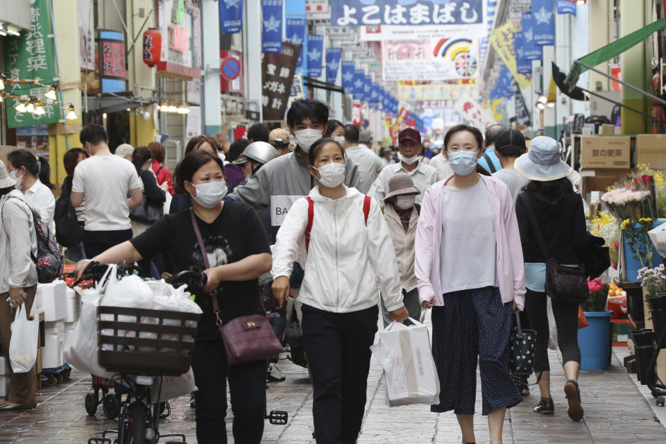 People wearing face masks shop at a mall in Yokohama, near Tokyo, Tuesday, June 23, 2020. Japan’s economy is opening cautiously, with social-distancing restrictions amid the coronavirus pandemic. (AP Photo/Koji Sasahara)