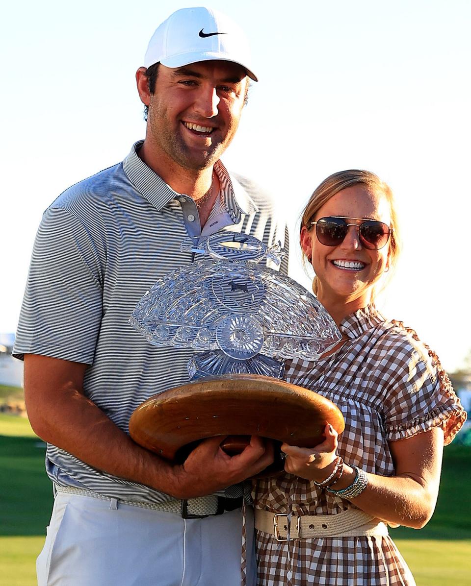 Scottie Scheffler of the United States poses with the trophy and his wife Meredith after winning the WM Phoenix Open at TPC Scottsdale on February 13, 2022 in Scottsdale, Arizona