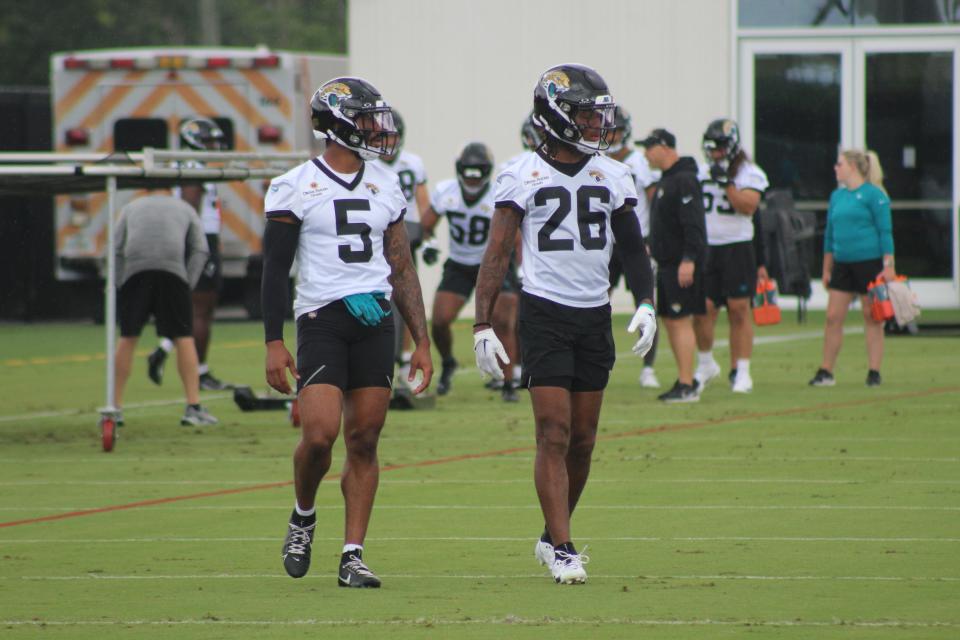 Andre Cisco and Antonio Johnson walk during the first day of OTAs.