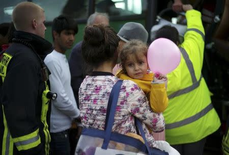 Migrants enter a bus on their way to a refugee camp after their arrival with a train in Dortmund, Germany September 6, 2015. REUTERS/Ina Fassbender