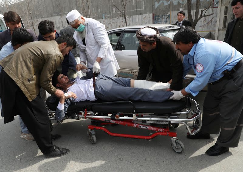 Hospital workers carry an injured person to an ambulance at a hospital after an attack in Kabul