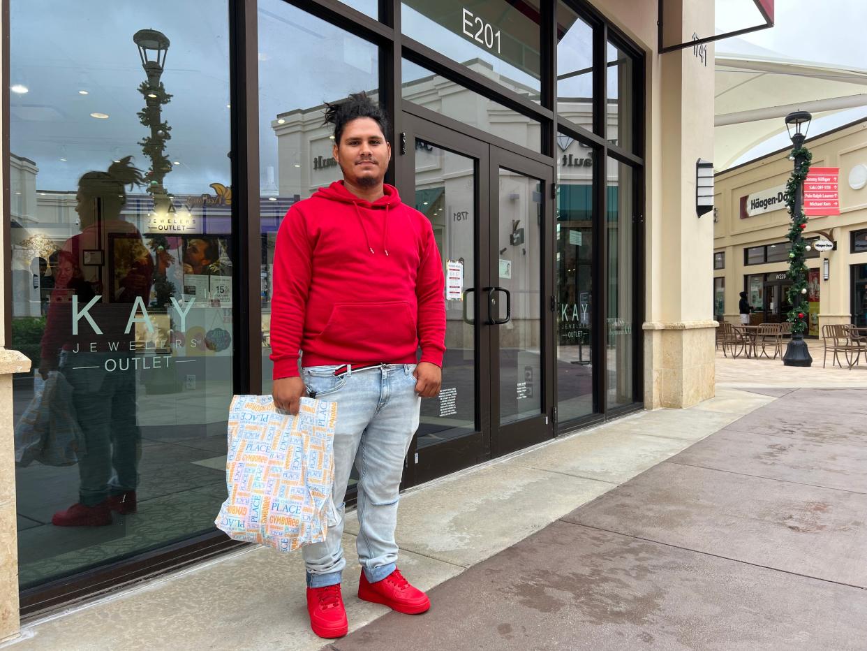 Luis Ortiz, 29, shops for his wife and children at Tanger Outlets on Super Saturday last year. Despite inflaiton, Ortiz said there were a number of discounts. Retailers at the open-air mall are not epxecting much of an impact from inflation this holiday shopping season either.