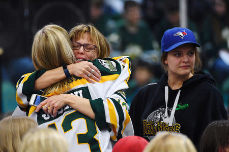 Mourners comfort each other during a vigil at the Elgar Petersen Arena, home of the Humboldt Broncos, to honour the victims of a fatal bus accident in Humboldt, Saskatchewan, Canada April 8, 2018. Jonathan Hayward/Pool via REUTERS