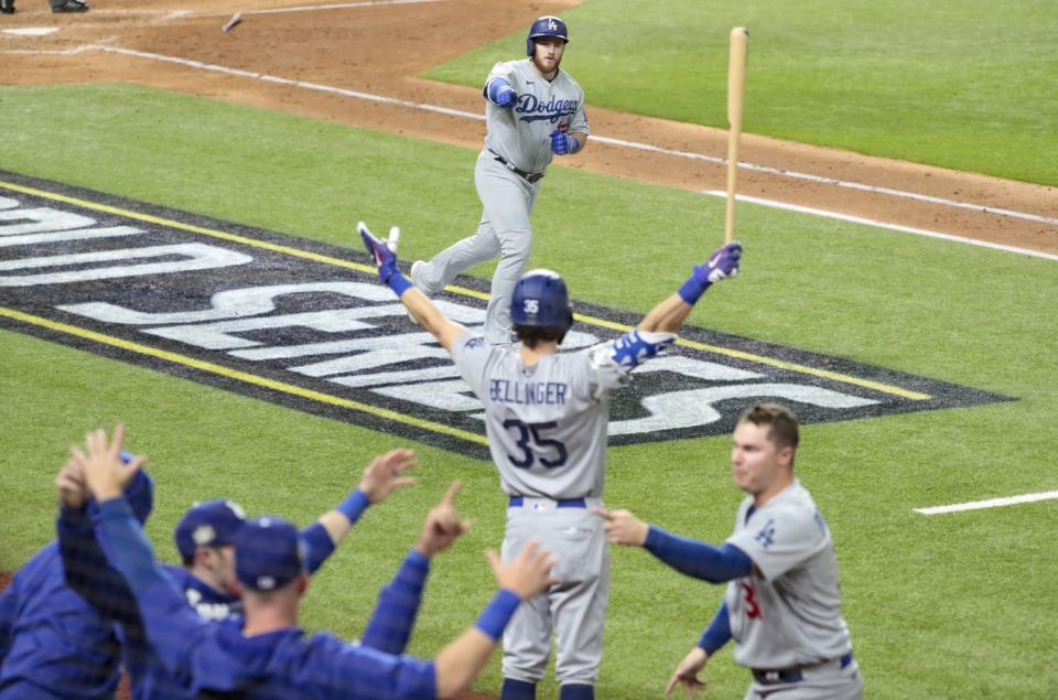 Max Muncy points at the Dodgers dugout as he rounds the bases following a fifth-inning home run.