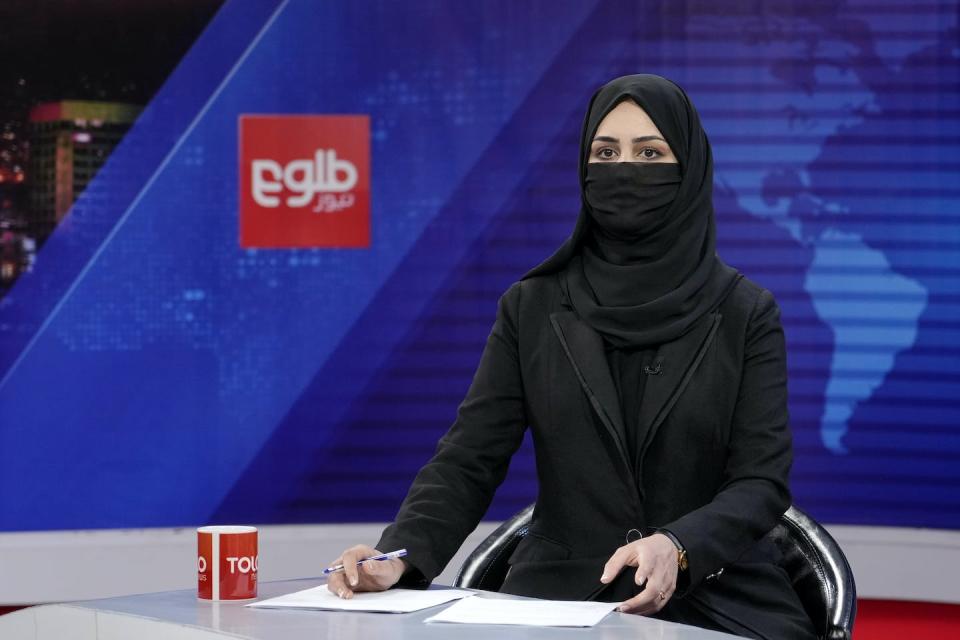 Khatereh Ahmadi, a TV anchor, wears a face covering as she reads the news on Tolo News in Kabul, Afghanistan, in May 2022. (AP Photo/Ebrahim Noroozi)